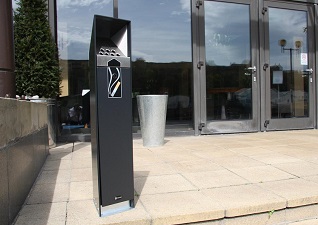 Ashguard™ Cigarette Bin for smoking control in black with smoking graphic at entrance way