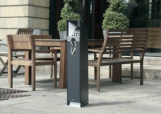 Ashguard™ free standing cigarette bin in black located next to outdoor picnic table