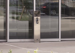 Ashguard™ Stainless Steel Cigarette Bin with metal finish and smoking logo outside building