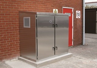 Cadet™ Enclosure Cabinet in stainless steel with double doors, sited against brick wall next to red door