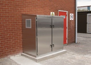 Cadet™ Enclosure in stainless steel with double doors against brick wall and red exit door