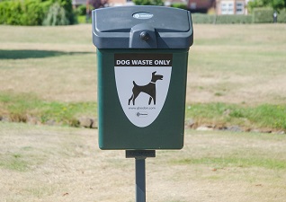 Fido™ 25 Dog Waste Bin in deep green with dog waste only sticker, post mounted in grass