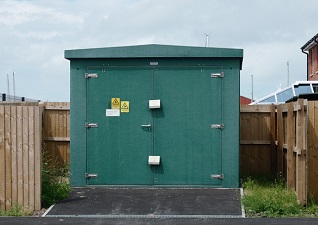 Fortress™ Industrial Enclosure Steel Housing in green for storing electrical equipment in a residential area