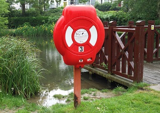 Guardian™ lifebuoy housing in red by lake for water safety