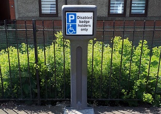 Infomaster™ Signed bollard indicating a disabled car parking spot in a residential area