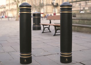 Jubilee™ Bollards in black with gold banding in city centre in front of traditional seating and litter bin