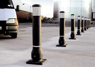 Neopolitan™ 150 Bollards in black with white banding, lined up in car park preventing vehicles