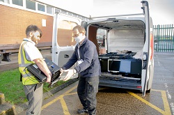 The IT department handing over teh monitor donation to Age UK Lancashire